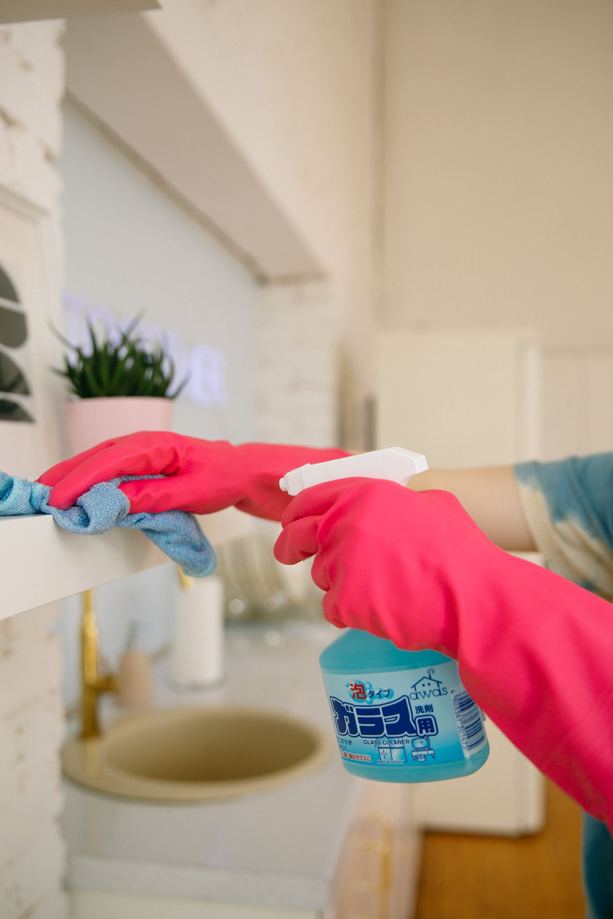 Ménage à domicile à Genève : nettoyage d’un plan de travail avec gants et spray
